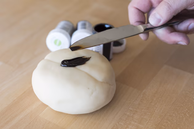 Das Modelliermarzipan färbt Moschen mit Pastenfarben ein. Diese enthalten kein Wasser und lösen das Marzipan deshalb nicht auf. Beim Färben vorsichtig vorgehen und immer nur eine Messerspitze Farbe verwende. Dann das Marzipan gut durchkneten.