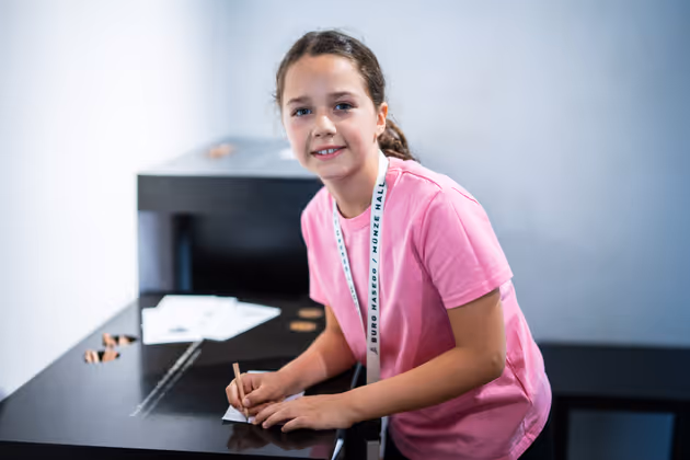 Anna (8) pauste eine Münze aufs Papier.