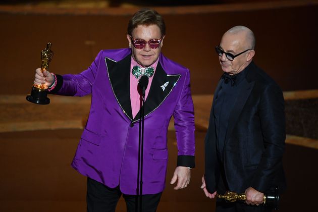 British singer-songwriter Elton John (L) and British lyricist Bernie Taupin accepts the award for Best Original Song for "(I'm Gonna) Love Me Again, 'Rocketman'" during the 92nd Oscars at the Dolby Theatre in Hollywood, California on February 9, 2020. (Photo by Mark RALSTON / AFP)