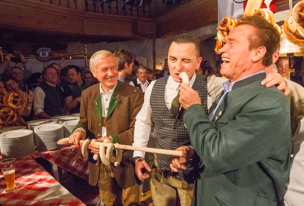 Stanglwirt Balthasar Hauser, Volks Rock´n Roller Andreas Gabalier der von Arnold Schwarzenegger (v. l.) gleich mit einer Weißwurst gefüttert wurde.