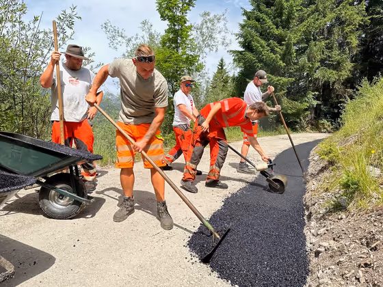 Heiße Angelegenheit: Strabag-Arbeiter asphaltieren bei einer Außentemperatur von mehr als 32 Grad einen Weg bei der Rotlechbrücke in Rieden im Außerfern. 