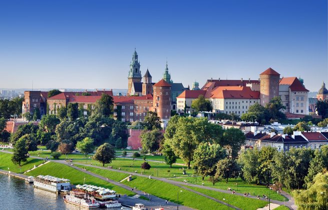 Historic royal Wawel castle in Cracow, Poland with park and Vistula river. Aerial view at sunset.