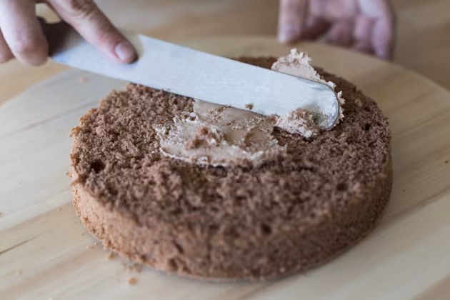 Moschen hat für die Ostertorte einen Schokobiskuit gebacken. Das Rezept gibt es auf seiner Homepage www.mannbackt.de. Die Buttercreme streicht er großzügig auf eine Tortenhälfte. Dabei ruhig über den Rand hinauskommen, denn auch außen wird Creme aufgetragen.