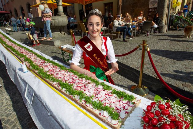 Radieschenprinzessin Diana Norz lässt es sich schmecken - und posiert stolz beim längsten Radieschenbrot Österreichs.