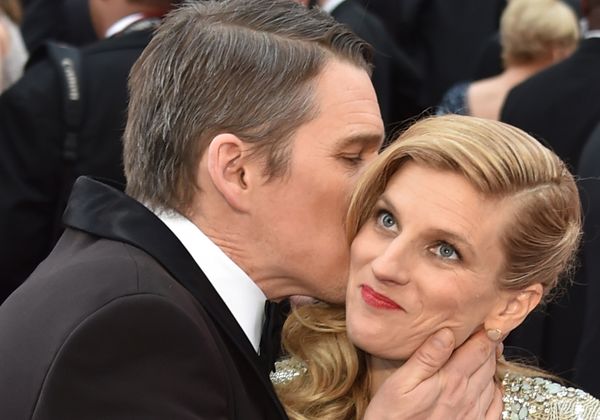 Was macht er denn da? Schauspieler Ethan Hawke scheint Ehefrau Ryan mit der Kuss-Attacke bei den Oscars 2015 überrumpelt zu haben.