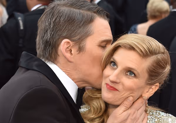 Was macht er denn da? Schauspieler Ethan Hawke scheint Ehefrau Ryan mit der Kuss-Attacke bei den Oscars 2015 überrumpelt zu haben.