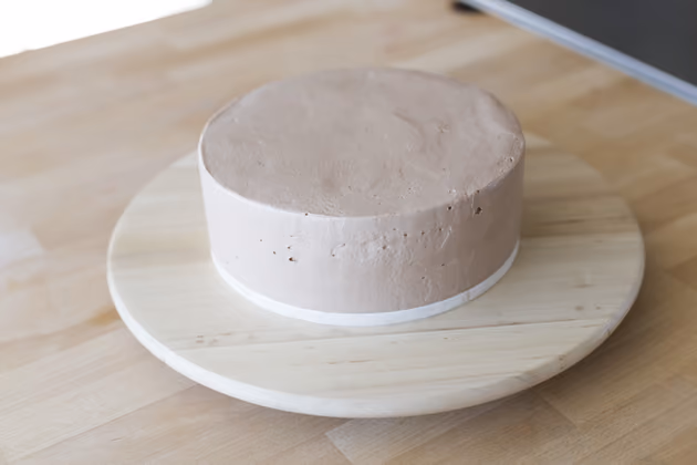 Das perfekte Endergebnis des Bloggers: Er hat die zweite Hälfte der Torte hinaufgesetzt und zunächst den oberen Teil mit Creme bestrichen. Dies gelingt am besten mit einer glatten Teigkarte. Am Ende wird der Rand mit Creme bedeckt. Doch keine Sorge, das Ergebnis muss nicht perfekt sein, Dekoration verdeckt Schönheitsfehler.