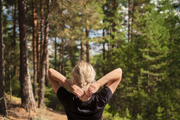 Beautiful woman against the background of a pine forest, forest baths, the idea of restoring health