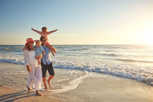 Happy family, beach holiday and walking, smile for vacation on tropical island. Man, woman and children together with sunglasses by ocean for travel with wellness, mockup space at sunset in Mauritius