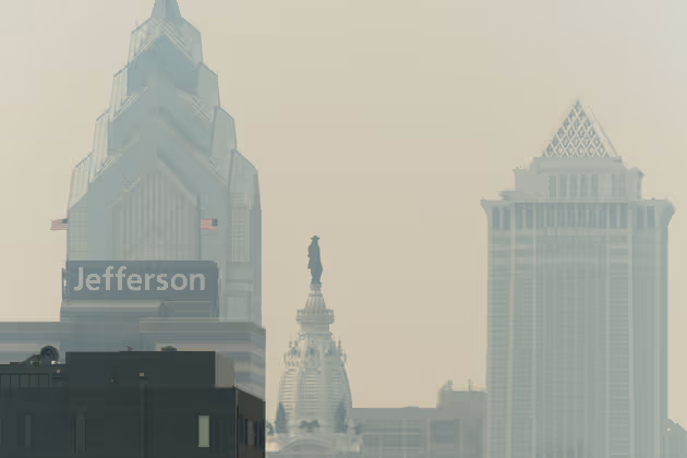 Smoke from Canada's wildfires casts a haze over the Philadelphia skyline, as seen from Camden, New Jersey on June 7, 2023. An orange-tinged smog caused by Canada's wildfires shrouded New York on June 7, 2023, obscuring skyscrapers and causing residents to don face masks, as cities along the US East Coast issued air quality alerts. (Photo by Joe LAMBERTI / AFP)