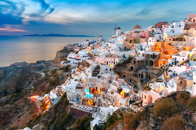 Picturesque famous view, Old Town of Oia or Ia on the island Santorini, white houses and windmills at sunset, Greece