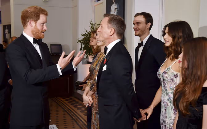 Heimliches Händchenhalten: Unbemerkt von Prinz Harry hielt Daniel Craig während des kurzen Plauschs die Hand seiner Ehefrau fest.