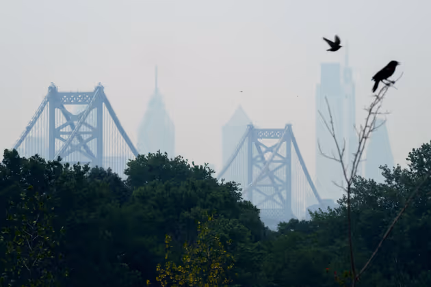 Smoke from Canada's wildfires casts a haze over the Philadelphia skyline, as seen from Camden, New Jersey on June 7, 2023. An orange-tinged smog caused by Canada's wildfires shrouded New York on June 7, 2023, obscuring skyscrapers and causing residents to don face masks, as cities along the US East Coast issued air quality alerts. (Photo by Joe LAMBERTI / AFP)