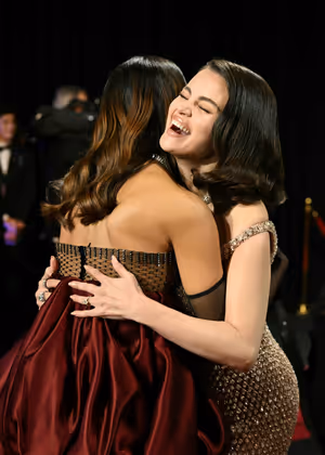 Selena Gomez (re.) and Zoe Saldana fallen sich in die Arme.
