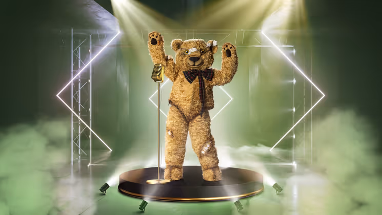 Ein Original: Der TEDDY erzählt die besten Geschichten aus den „guten alten Zeiten“. Wenn er anfängt, hängen alle an seinen Lippen. Die Maske besteht aus original Steiff-Fell, das so steif ist, dass das Kostüm aus 19 unabhängigen Gliedern gefertigt wurde, damit der Teddy sich bewegen kann.