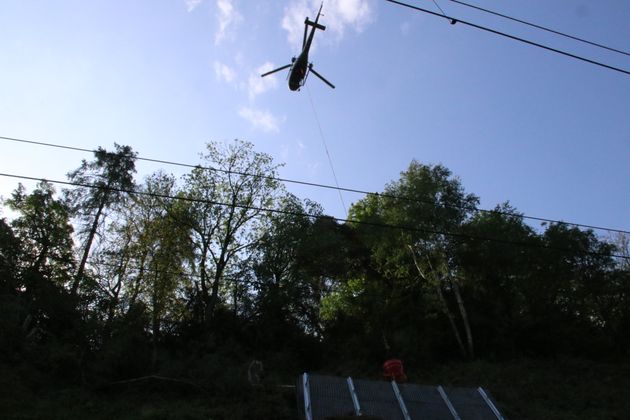 Ein Helikopter fliegt Kies zur Baustelle. In das Material kann Regenwasser einsickern. Über ein Drainage-Rohr gelangt es in den Inn.